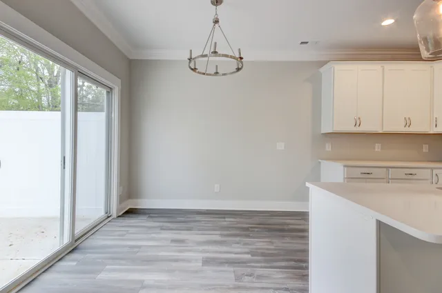 a view of a kitchen with wooden floor and cabinets