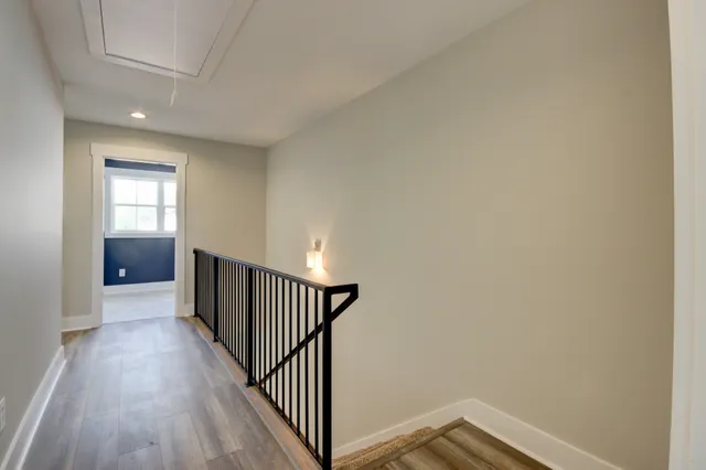 a view of a hallway with wooden floor and closet