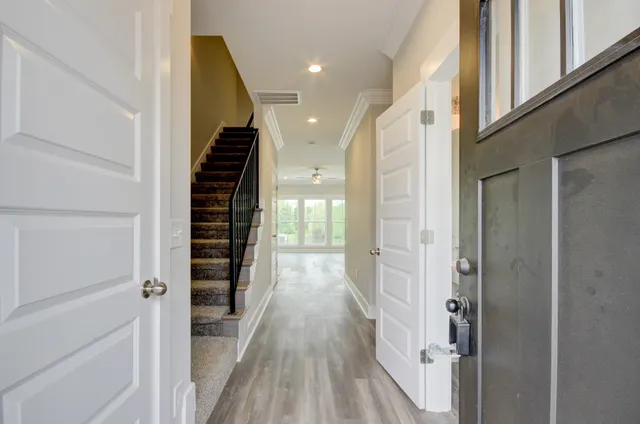 a view of a hallway with wooden floor and staircase