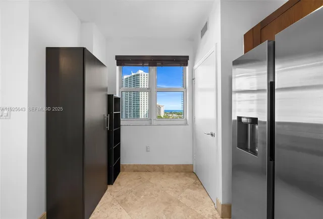 a kitchen with a refrigerator and a washer dryer