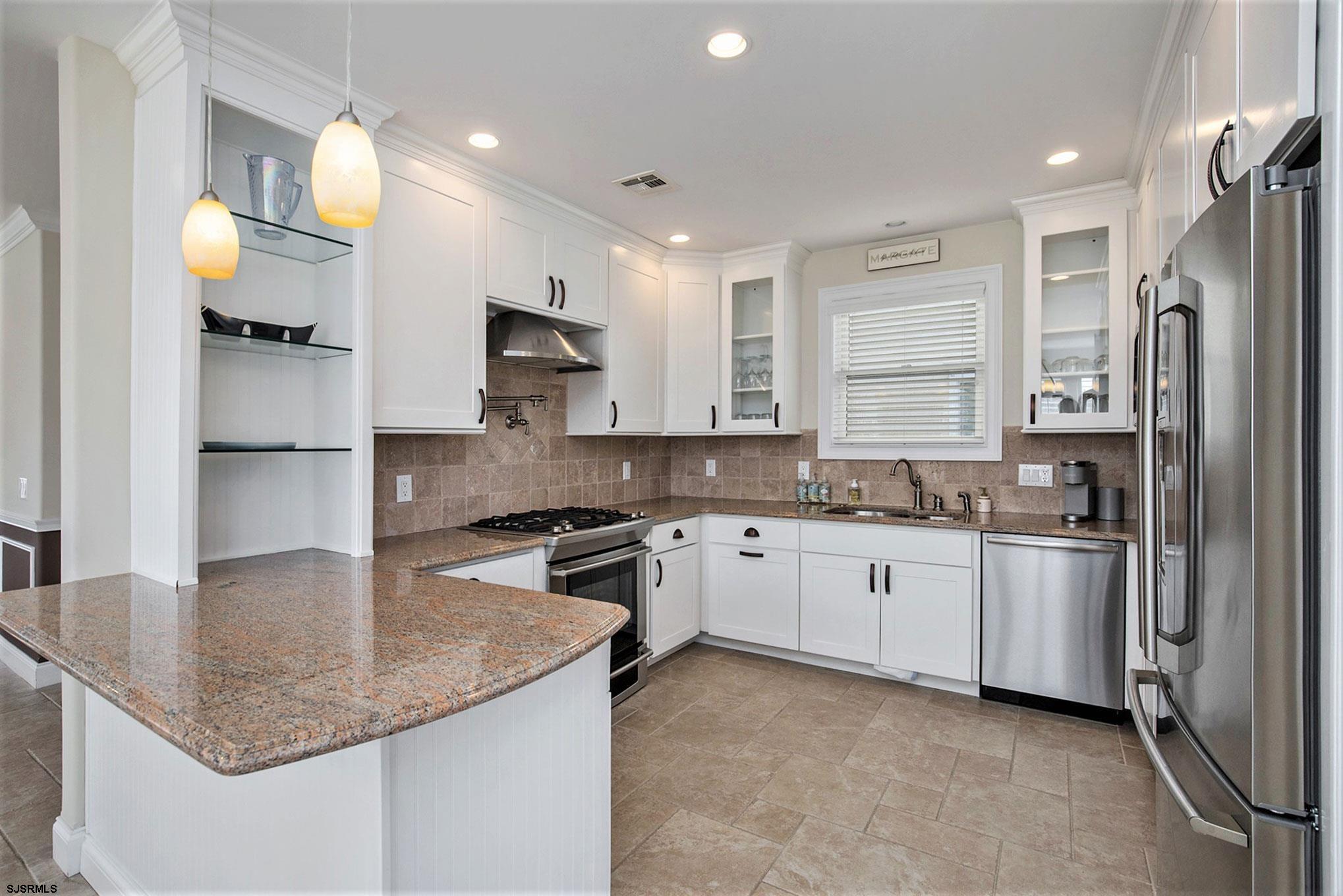 7611 Ventnor Avenue, Unit JUNE 2026 Margate City, NJ 08402 - Photo 15 of 49 a kitchen with stainless steel appliances granite countertop a sink stove and refrigerator