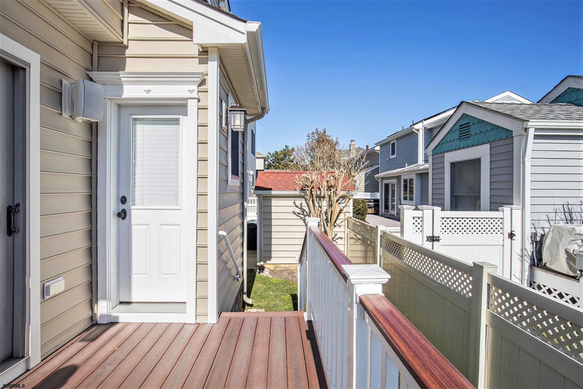 7611 Ventnor Avenue, Unit JUNE 2026 Margate City, NJ 08402 - Photo 17 of 49 a view of a balcony with wooden floor and fence