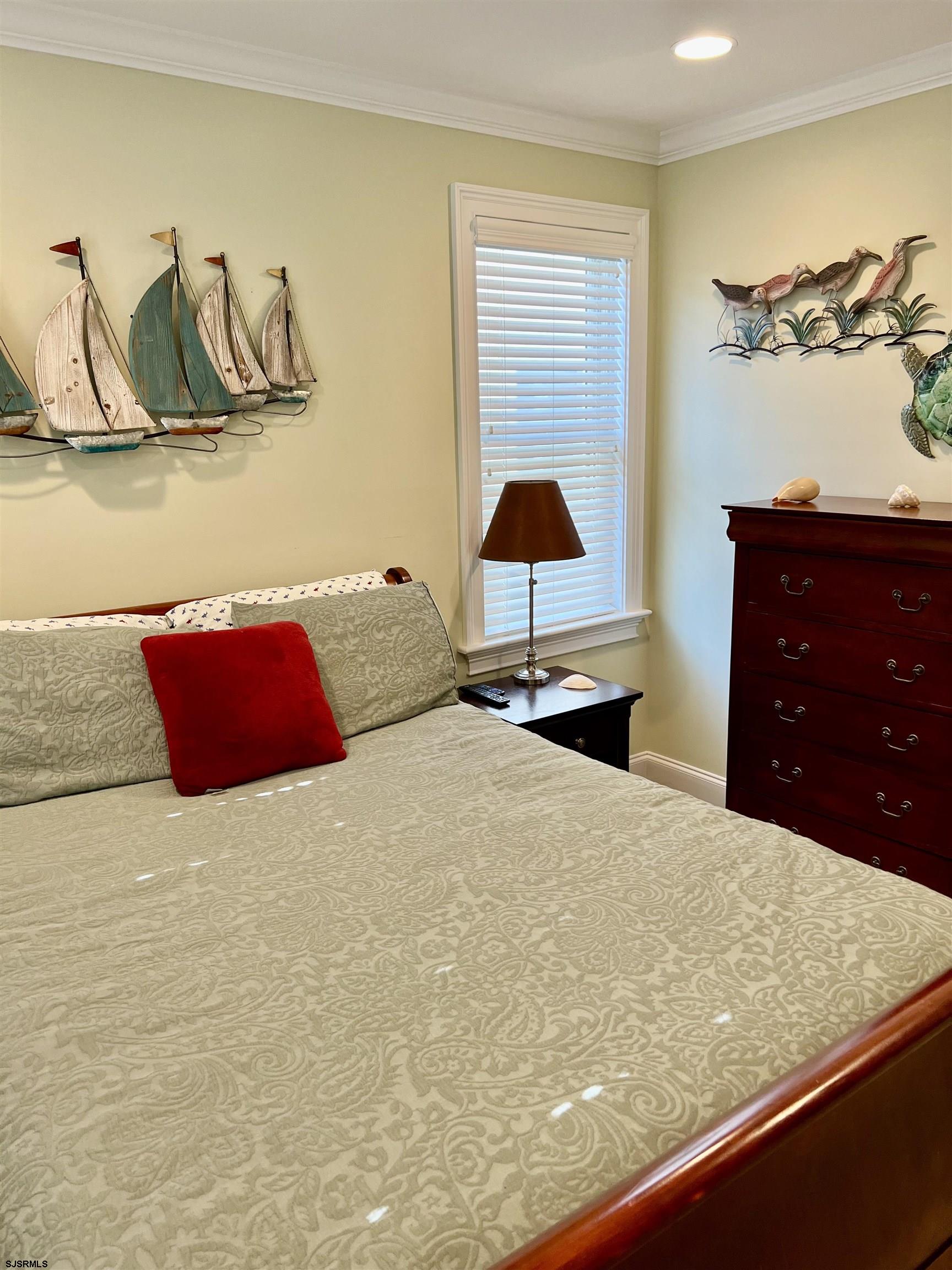 7611 Ventnor Avenue, Unit JUNE 2026 Margate City, NJ 08402 - Photo 22 of 49 a bedroom with a bed and a lamp