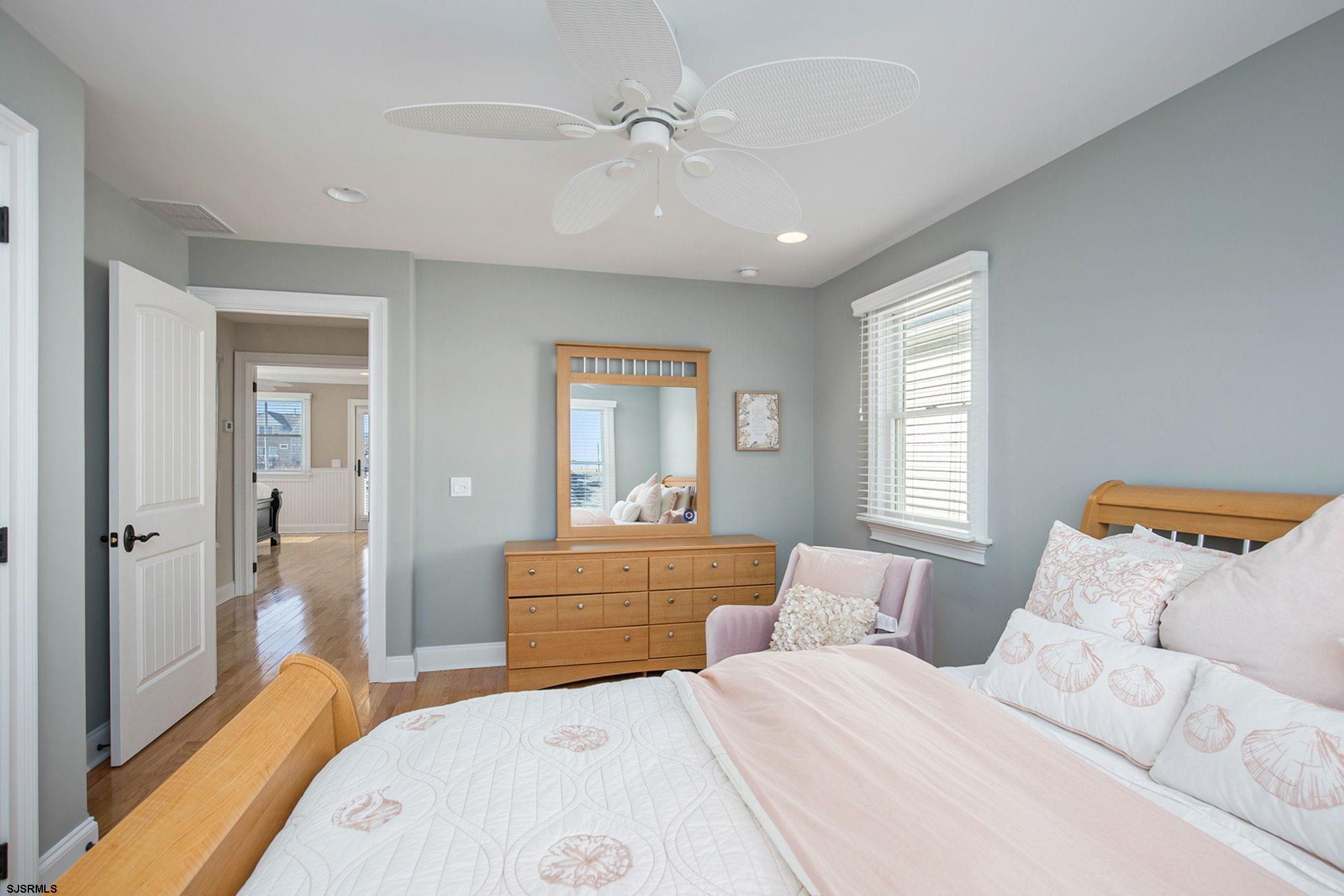 7611 Ventnor Avenue, Unit JUNE 2026 Margate City, NJ 08402 - Photo 24 of 49 a bedroom with a bed and a chandelier fan