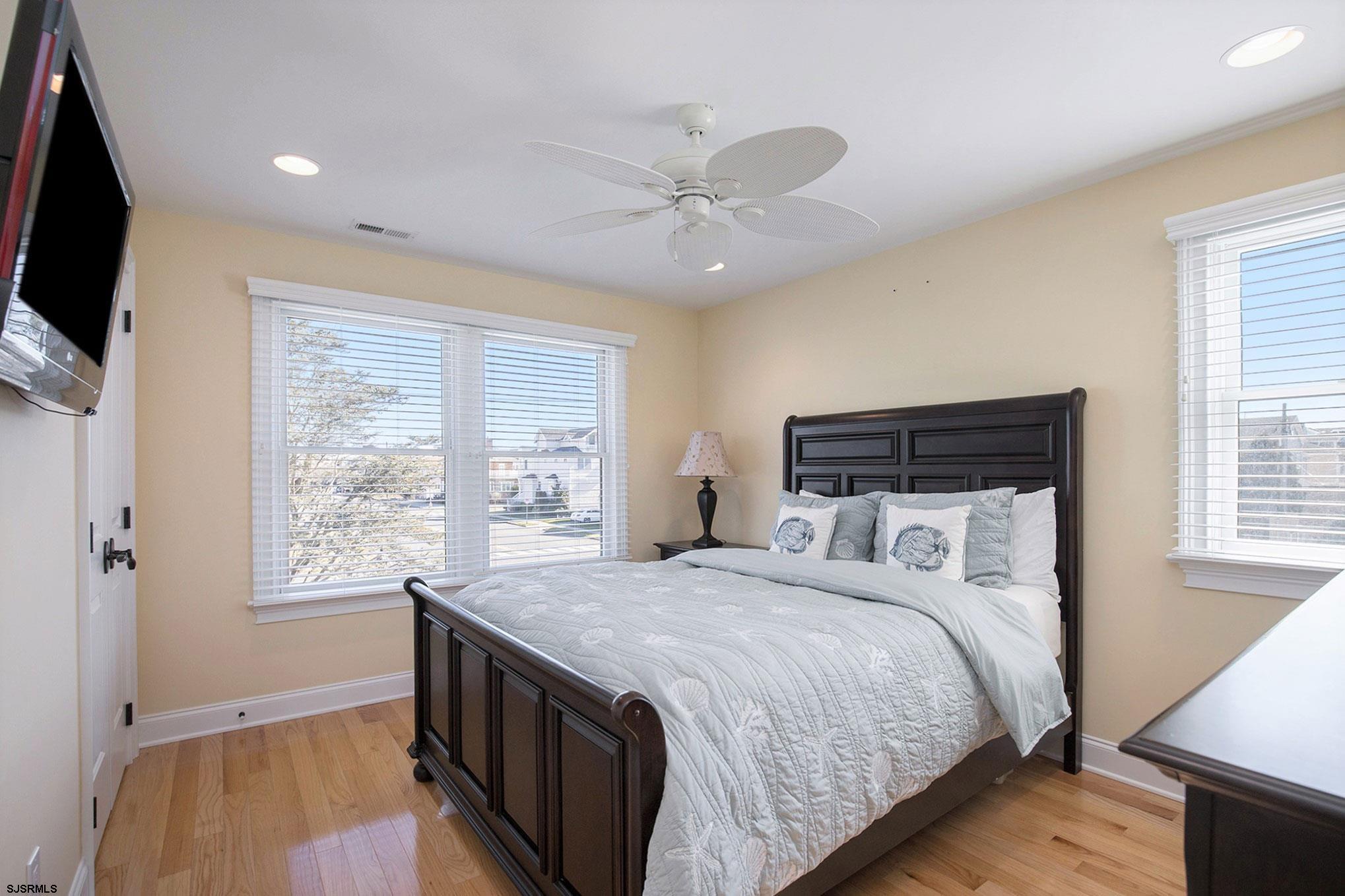 7611 Ventnor Avenue, Unit JUNE 2026 Margate City, NJ 08402 - Photo 25 of 49 a bedroom with a bed and a flat screen tv