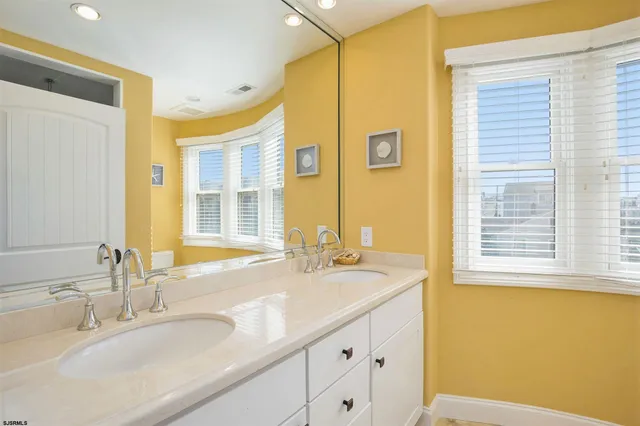 a bathroom with a granite countertop sink and a large mirror