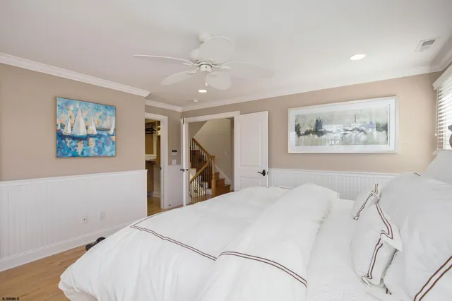 a bedroom with a large bed and a chandelier