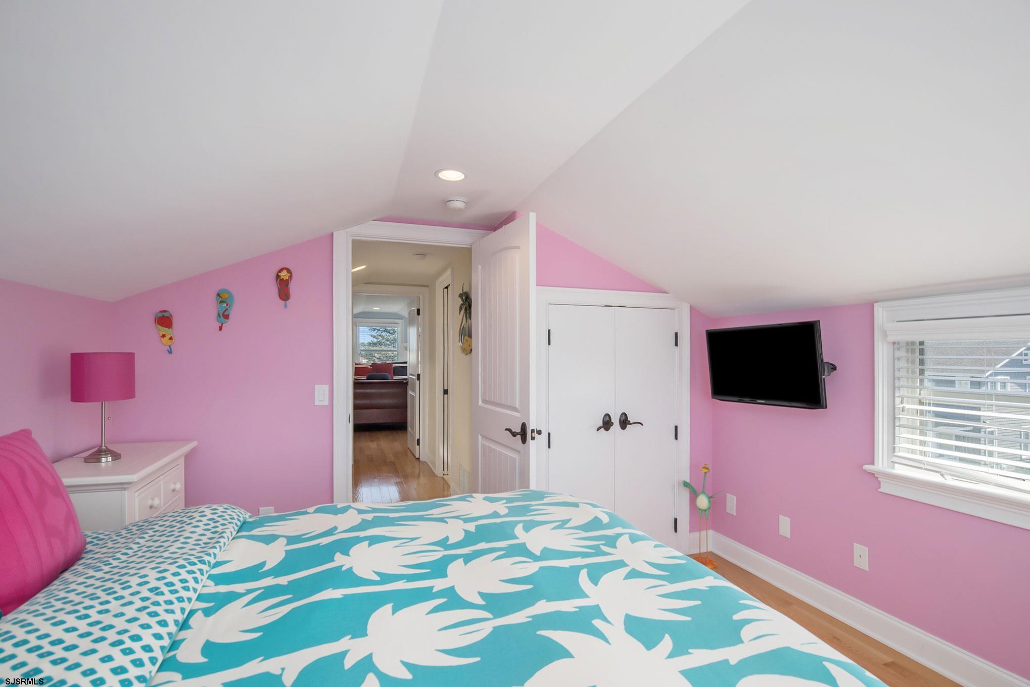 7611 Ventnor Avenue, Unit JUNE 2026 Margate City, NJ 08402 - Photo 43 of 49 a bedroom with a bed and a flat screen tv