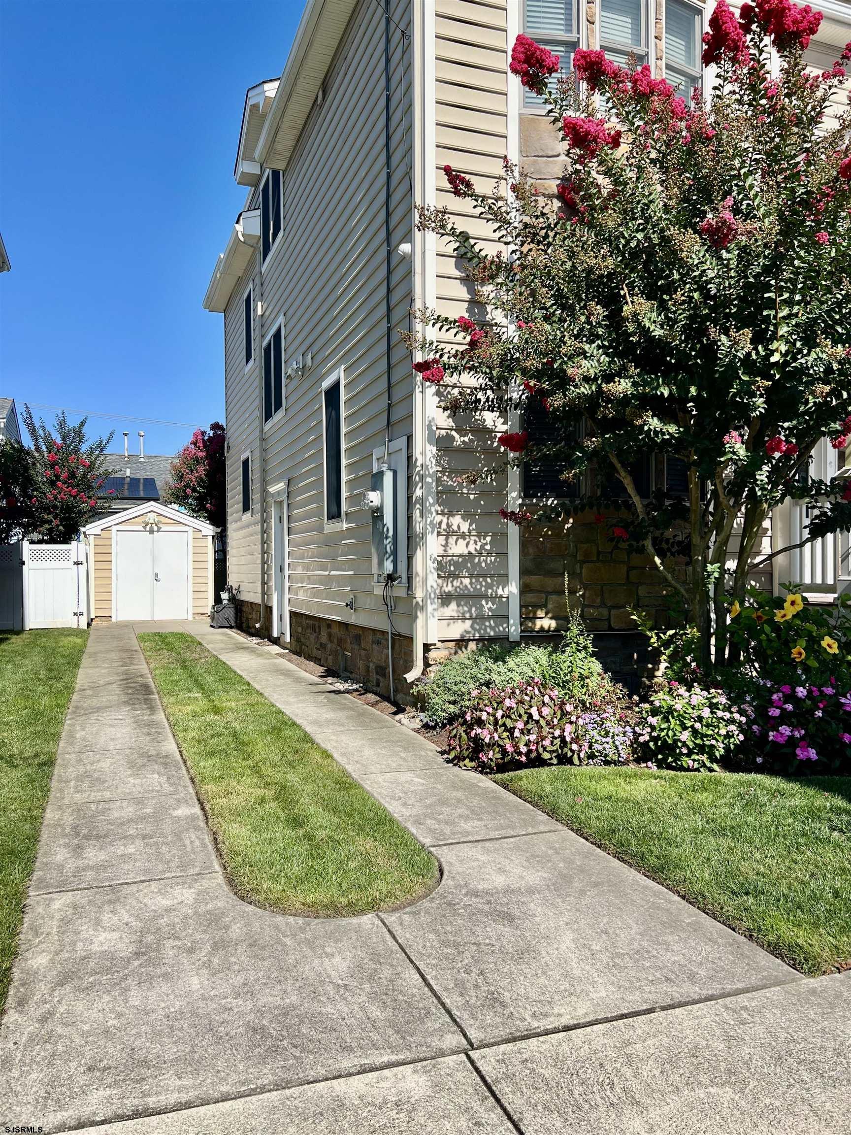 7611 Ventnor Avenue, Unit JUNE 2026 Margate City, NJ 08402 - Photo 49 of 49 a view of a house with a small yard and a garage
