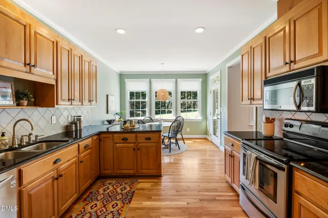 a kitchen with granite countertop white cabinets and black appliances