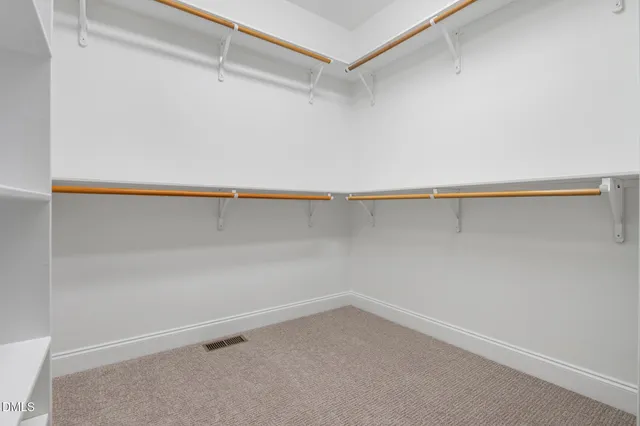a view of an empty room with closet and entryway