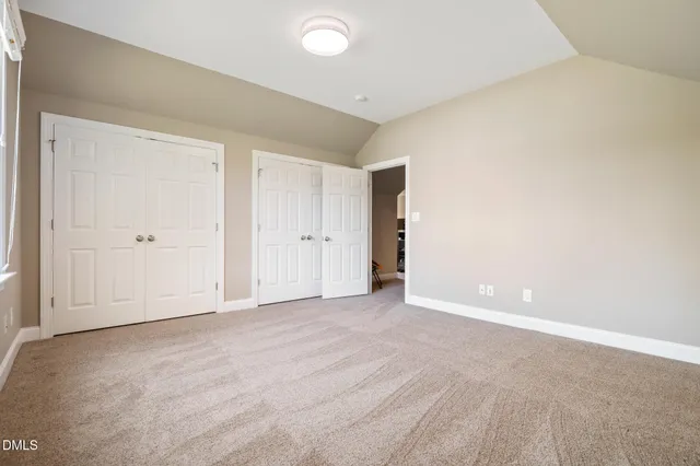 a view of the house with backyard and bushes