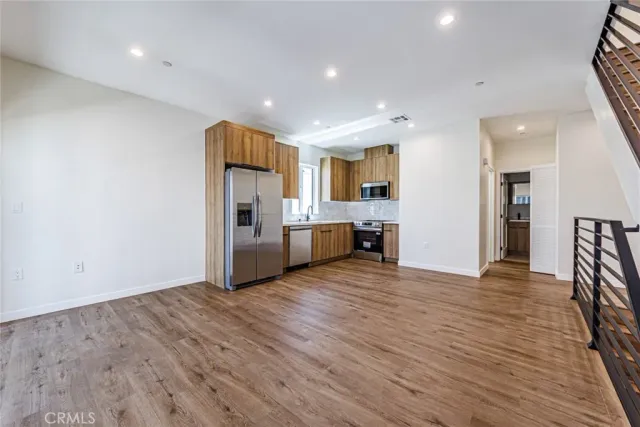 a view of a kitchen with wooden floor and a refrigerator