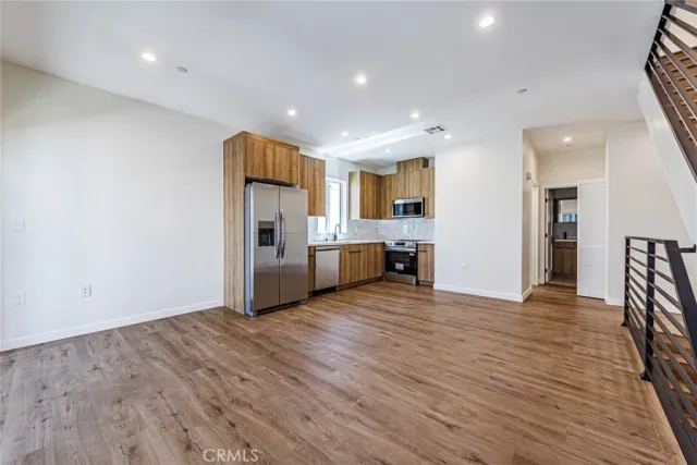 a view of a kitchen with wooden floor and a refrigerator