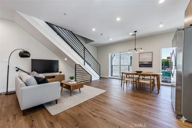 a living room with furniture flat screen tv and wooden floor