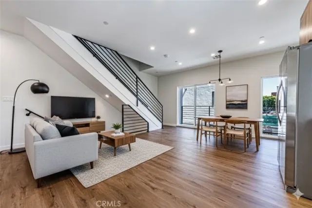 a living room with furniture flat screen tv and wooden floor