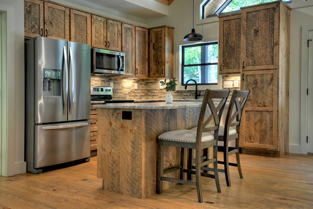 187 Chickadee Road Morganton, GA 30560 - Photo 4 of 94 a kitchen with stainless steel appliances granite countertop a refrigerator a stove a dining table and chairs