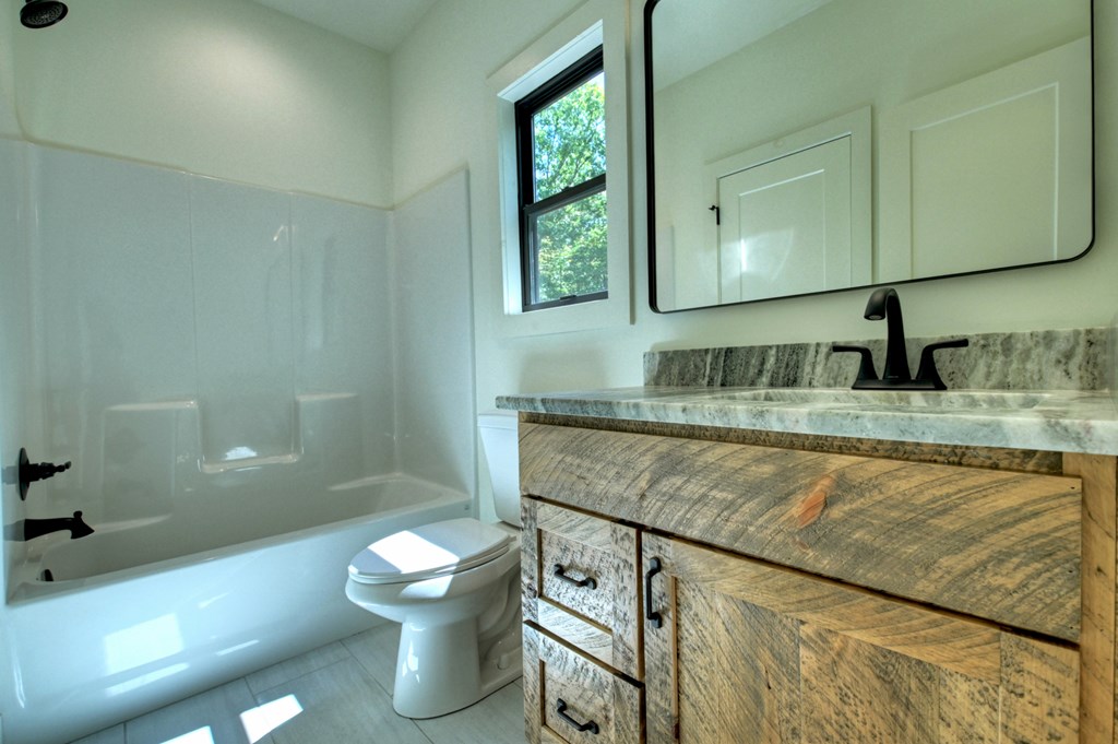 187 Chickadee Road Morganton, GA 30560 - Photo 77 of 94 a bathroom with a granite countertop toilet sink and mirror