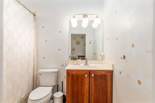 a bathroom with a sink a toilet and a large mirror