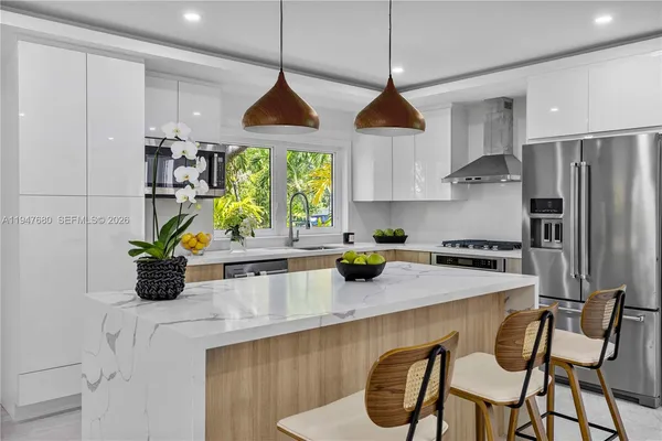 a kitchen with stainless steel appliances granite countertop a sink a stove and a refrigerator