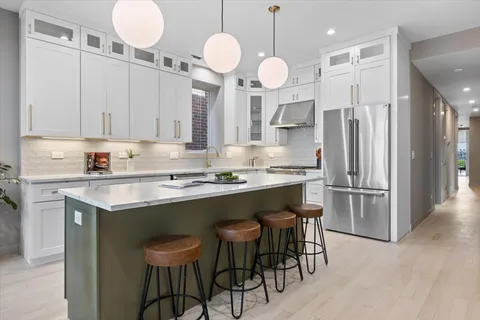 a kitchen with a sink stainless steel appliances and white cabinets