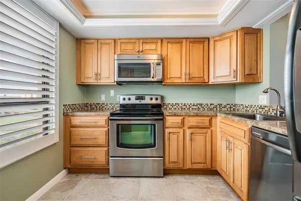 a kitchen with stainless steel appliances granite countertop a stove a sink and a microwave