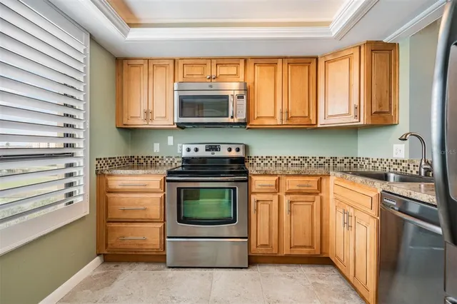 a kitchen with stainless steel appliances granite countertop a stove a sink and a microwave