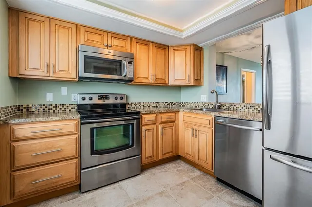 a kitchen with stainless steel appliances granite countertop a stove and a microwave