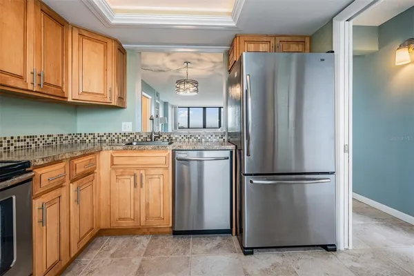 a kitchen with stainless steel appliances granite countertop a refrigerator and a stove