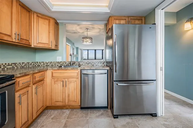 a kitchen with stainless steel appliances granite countertop a refrigerator and a stove