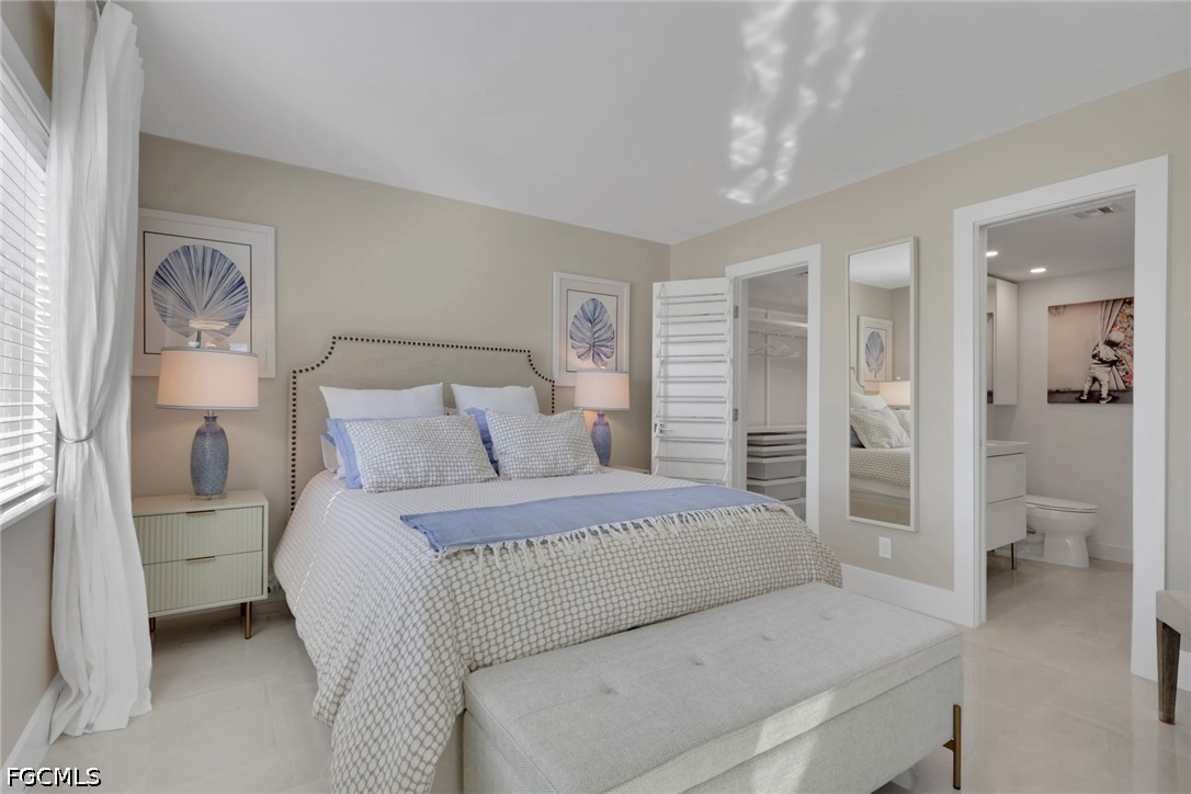 9 High Point Circle North, Unit 101 Naples, FL 34103 - Photo 18 of 49 a bedroom with a large bed and a chandelier