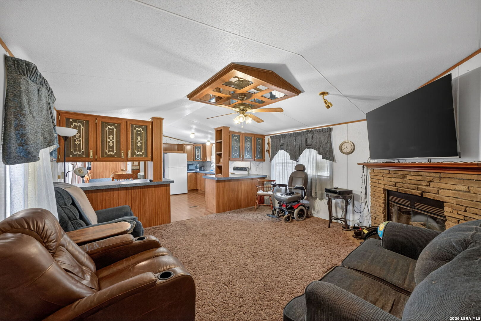 23398 Mathis Road Elmendorf, TX 78112 - Photo 6 of 18 a living room with furniture a fireplace and a flat screen tv