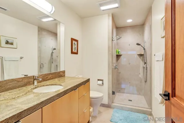 a bathroom with a granite countertop sink mirror toilet and bathtub