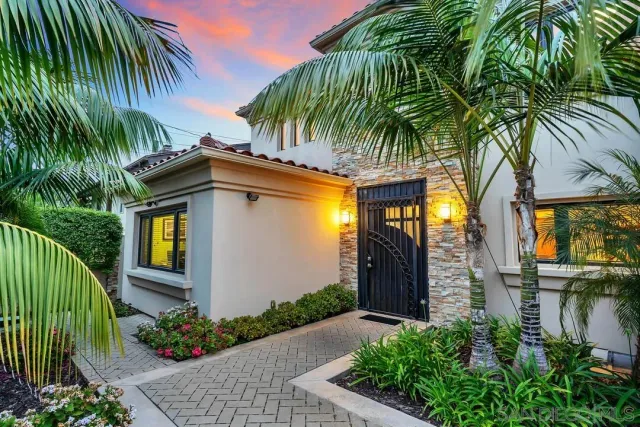 a view of a house with a yard plants and palm trees