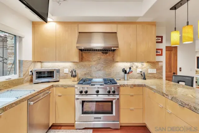 a kitchen with stainless steel appliances granite countertop sink stove top oven and cabinets