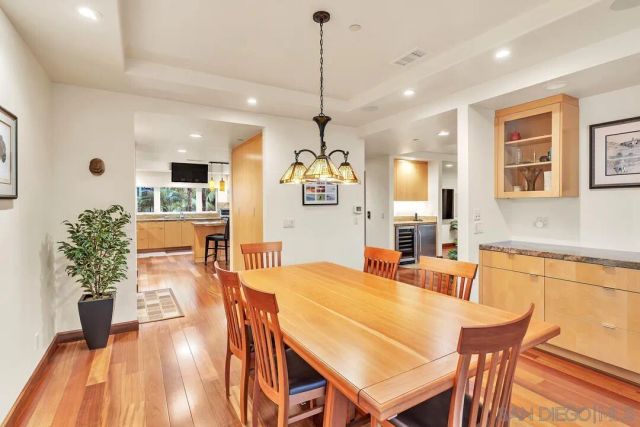 a kitchen with stainless steel appliances granite countertop a stove a refrigerator a sink a dining table and chairs