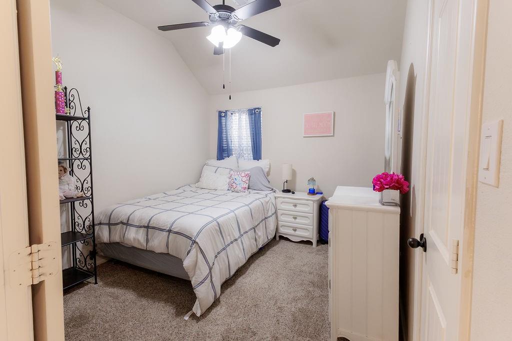 544 Madrone Trail Forney, TX 75126 - Photo 13 of 23 a bedroom with a bed and a chandelier