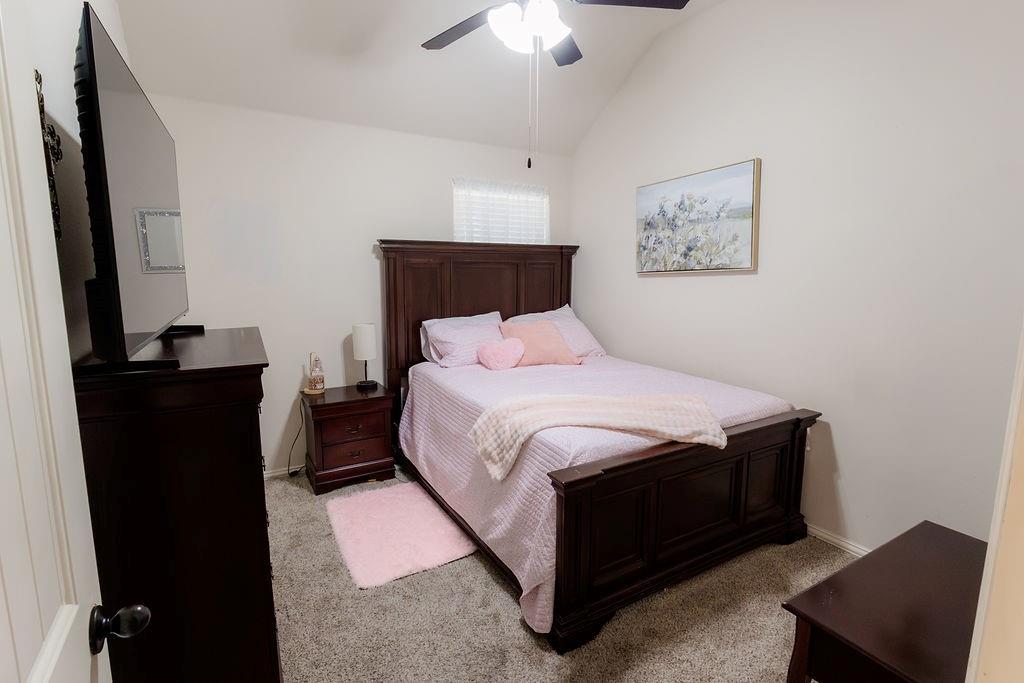 544 Madrone Trail Forney, TX 75126 - Photo 15 of 23 a bedroom with a bed and a chandelier