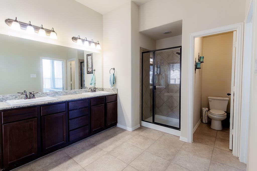 544 Madrone Trail Forney, TX 75126 - Photo 20 of 23 a spacious bathroom with a double vanity sink toilet and shower