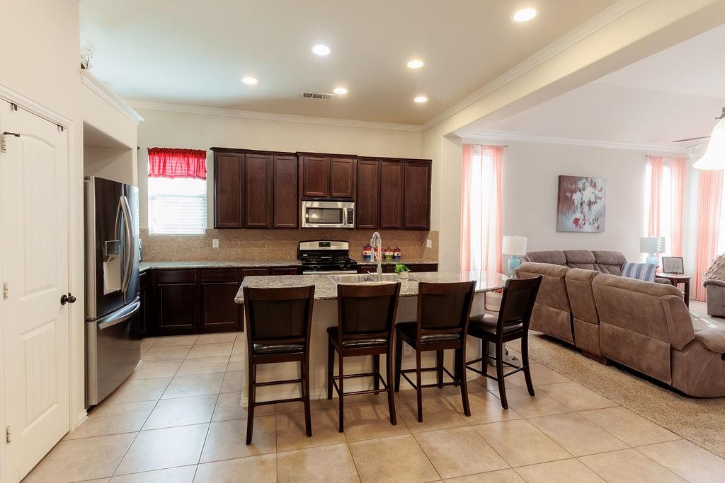 544 Madrone Trail Forney, TX 75126 - Photo 8 of 23 a kitchen with granite countertop cabinets and refrigerator