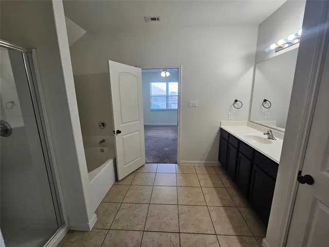 an empty room with windows and a chandelier fan
