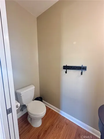 a white toilet sitting next to a wooden cabinet