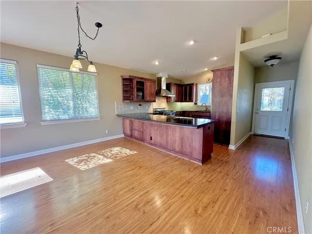 a kitchen with stainless steel appliances granite countertop a stove a sink dishwasher and a large oven with wooden floor