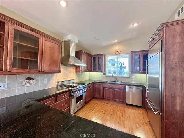 a kitchen with stainless steel appliances granite countertop sink stove top oven and cabinets