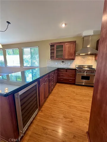 a large kitchen with stainless steel appliances granite countertop a stove a sink and a microwave