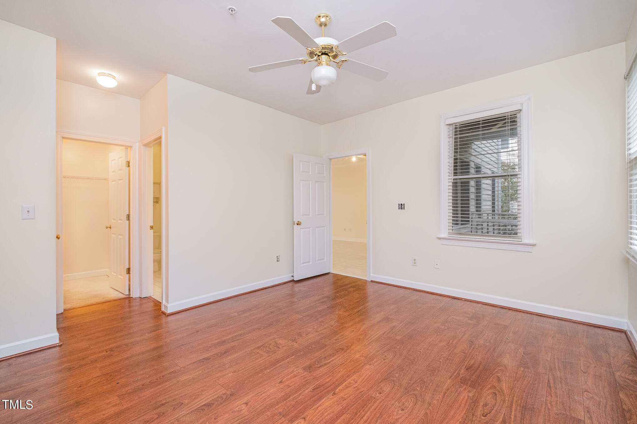 2651 Mellowfield Drive, Unit 107 Raleigh, NC 27604 - Photo 10 of 15 a view of an empty room with window a ceiling fan and wooden floor
