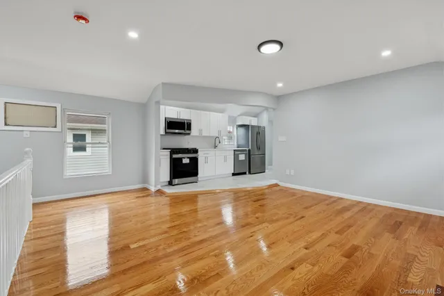 a view of empty room with wooden floor and fireplace
