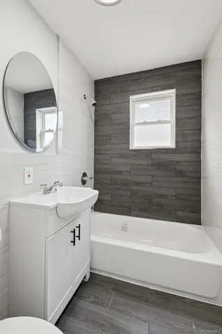 a bathroom with a bathtub sink mirror and toilet