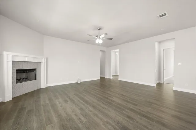 a view of an empty room with a fireplace and a window