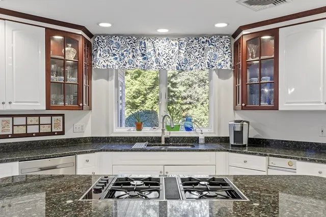 a kitchen with granite countertop white cabinets and white appliances